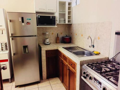 a kitchen with a stainless steel refrigerator and a sink at Exclusivo Apartamento en el Centro de Trujillo in Trujillo