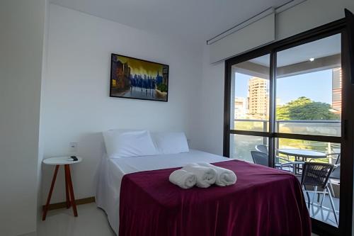 1 dormitorio con 1 cama y 1 toalla en una mesa en H.E 301 · Lindo Apt com Varanda - Caminho das árvores, en Salvador