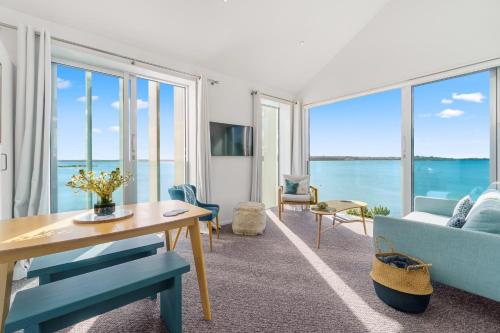 a living room with a view of the ocean at Harbour View - Westmere Holiday Apartment in Auckland