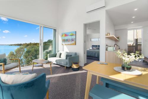 a living room with a view of the water at Harbour View - Westmere Holiday Apartment in Auckland