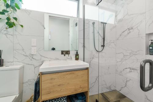a bathroom with a sink and a shower at Harbour View - Westmere Holiday Apartment in Auckland