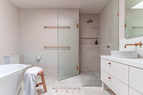a white bathroom with a glass shower backdoor at Winifred in Red Hill South