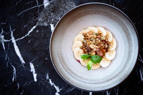 a bowl of food with banana slices and nuts at Kamana Lakehouse in Queenstown