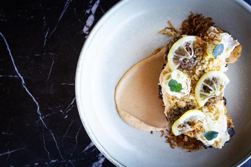 a white bowl filled with food with lemon slices at Kamana Lakehouse in Queenstown
