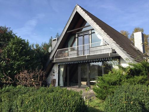 a house with a thatched roof with a balcony at Ferienhaus im Birkenweg in Worpswede