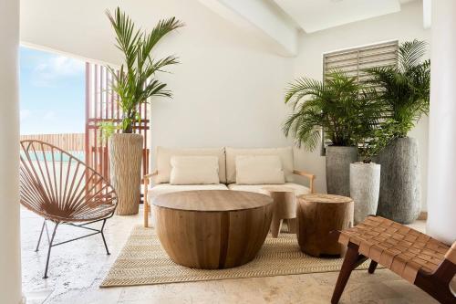 a living room with a coffee table and potted plants at Courtyard by Marriott Aruba Resort in Palm-Eagle Beach