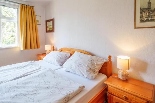 1 dormitorio con cama blanca y ventana en Alandblick Apartments, en Wanzer