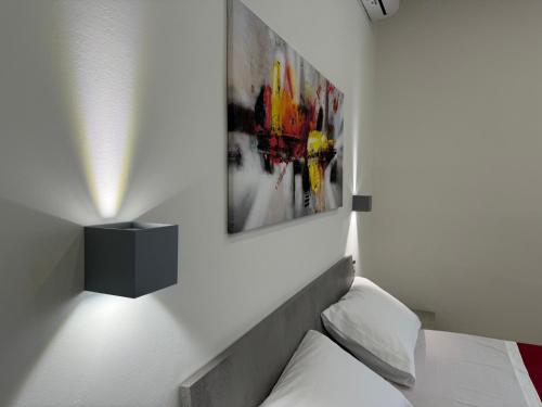 a bedroom with a bed and a picture on the wall at Casa Vacanze La Perla Rara in Taranto