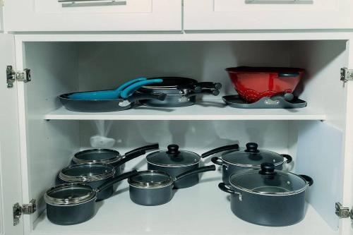 a bunch of pots and pans on a shelf at Happy Beach House in Biloxi in Biloxi