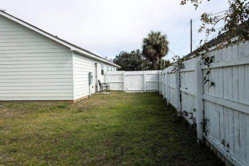 a white fence next to a white house at Happy Beach House in Biloxi in Biloxi