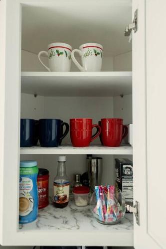 a cabinet filled with cups and other kitchen items at Happy Beach House in Biloxi in Biloxi