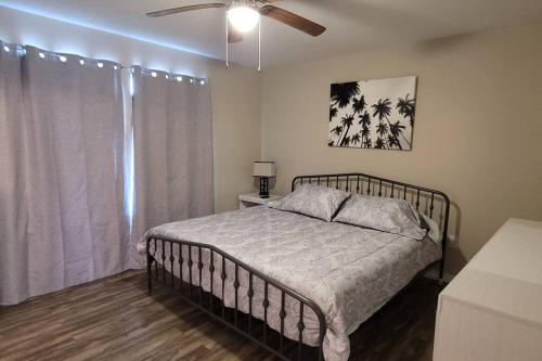 a bedroom with a bed and a ceiling fan at Happy Beach House in Biloxi in Biloxi