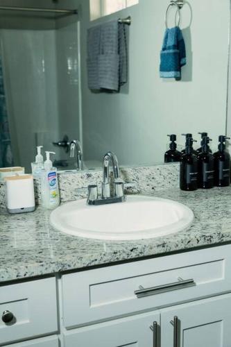 a bathroom counter with a sink and a mirror at Happy Beach House in Biloxi in Biloxi