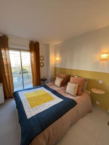 une chambre avec un grand lit avec une grande fenêtre dans l'établissement Superbe 70m2 avec terrasses, proche de la plage, à Sainte-Maxime