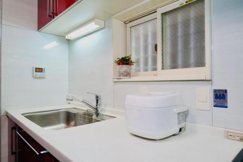 una cocina con fregadero y encimera en 京都佳月民宿, en Kioto