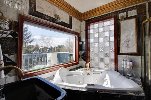een badkamer met een bad en een raam bij Lake View Paradise Cottage in Newcastle