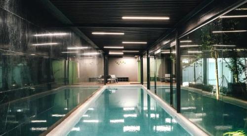 a large swimming pool in a building with glass walls at Amazing 2BR in Condesa in Mexico City