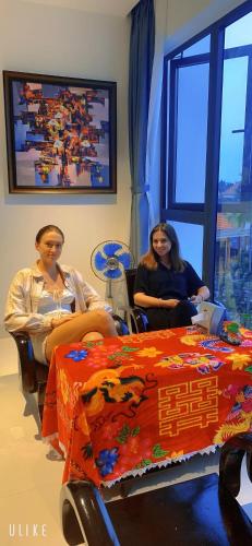 two women sitting in chairs next to a table with a cake at The Dragon Villa Hoi An in Hoi An