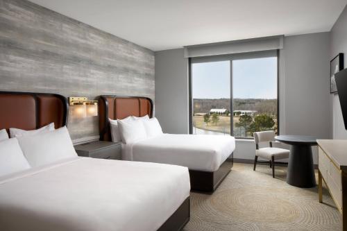 a hotel room with two beds and a window at Trilith Guesthouse, Fayetteville, GA, a Tribute Portfolio Hotel in Fayetteville