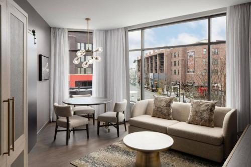 a living room with a couch and a table at Trilith Guesthouse, Fayetteville, GA, a Tribute Portfolio Hotel in Fayetteville