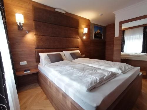 a bedroom with a large bed with a wooden headboard at GOLDEN STAR - Premium Apartments in Melk