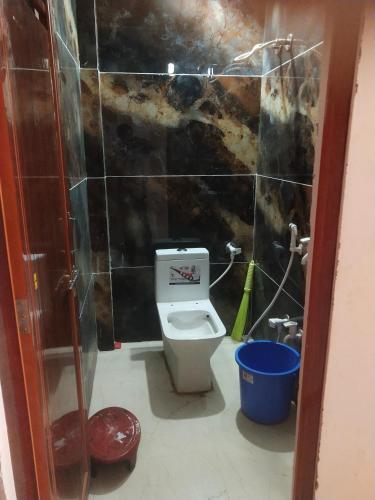 a small bathroom with a toilet and a shower at Maa yatri niwas (home stay) in Ujjain
