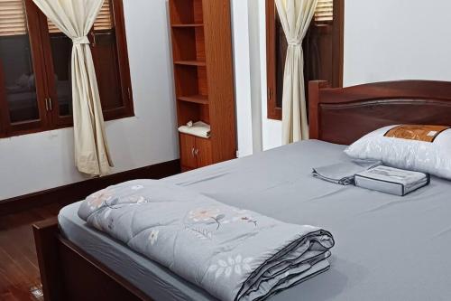 Un dormitorio con una cama con una manta. en MEKONG VIEW VILLE en Vientián