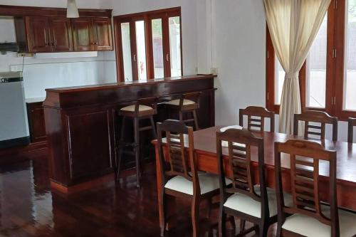uma sala de jantar com uma mesa de madeira e cadeiras em MEKONG VIEW VILLE em Vientiane
