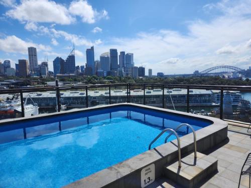 a swimming pool on top of a building with a city skyline at The Gem-Executive Potts Point Harbourview Stunner in Sydney