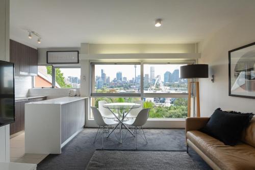 a kitchen and living room with a table and a couch at The Gem-Executive Potts Point Harbourview Stunner in Sydney