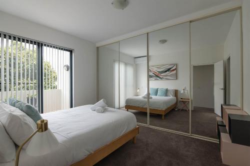a bedroom with a bed and a large mirror at Treetops Camperdown Inner City Bliss w Parking in Sydney