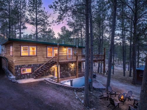 a log cabin in the woods with a deck at Modern Lodge- BHBungalows Main in Custer