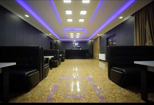 Tsqaltubo的住宿－Hotel Oasis Villa，一间会议室,配有黑色椅子和紫色天花板