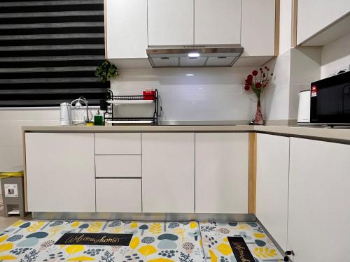 a kitchen with white cabinets and a counter top at Netflix-Seaview-SunsetView-PuteriBeach-Mutiara Beach Resort Melaka in Kampong Pantai Dusun