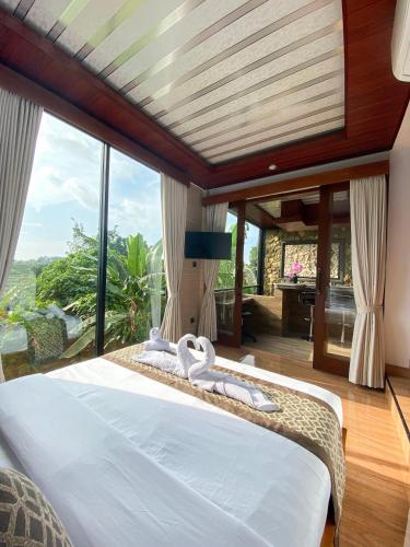 una camera da letto con un grande letto con una grande finestra di Tori Klumpu Bali South Ubud a Badung