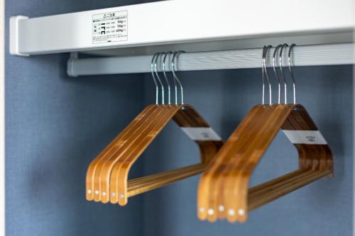 two wooden chopsticks hanging from a kitchen counter at 67 Apt Koenji Tokyo in Tokyo