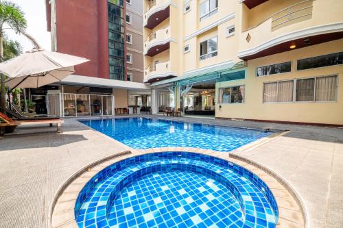 ein Schwimmbad in der Mitte eines Gebäudes in der Unterkunft J A Plus Hotel in Pattaya