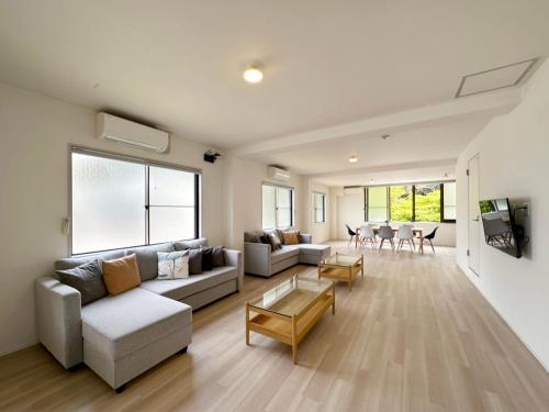 a living room with a couch and a table at bHOTEL Kaniwasou 201 2BR Apt, Near Itsukushima Shrine, For 12 Ppl in Hatsukaichi