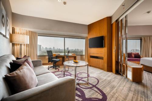 a hotel room with a couch and a table at Centara Grand at Central Plaza Ladprao Bangkok in Bangkok