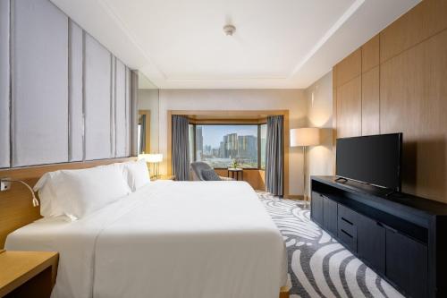 a hotel room with a bed and a flat screen tv at Centara Grand at Central Plaza Ladprao Bangkok in Bangkok