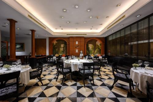 a dining room with tables and chairs with white tablecloths at Centara Grand at Central Plaza Ladprao Bangkok in Bangkok