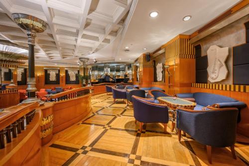 a restaurant with blue chairs and a guitar on the wall at Centara Grand at Central Plaza Ladprao Bangkok in Bangkok
