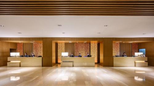 a lobby of a hotel with people sitting at reception desks at Centara Grand at Central Plaza Ladprao Bangkok in Bangkok