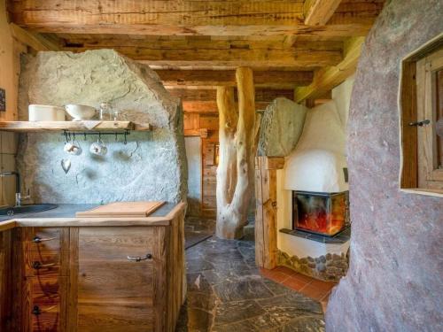 a kitchen with a fireplace in a log cabin at Lush holiday home with sauna in Grän