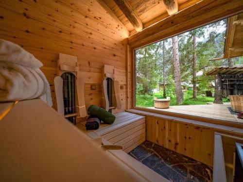 a room with a large window in a wooden cabin at Lush holiday home with sauna in Grän