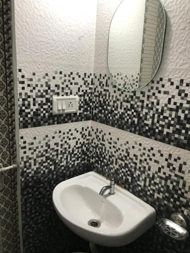 a bathroom with a sink and a mirror at Gods own home stay in Cochin