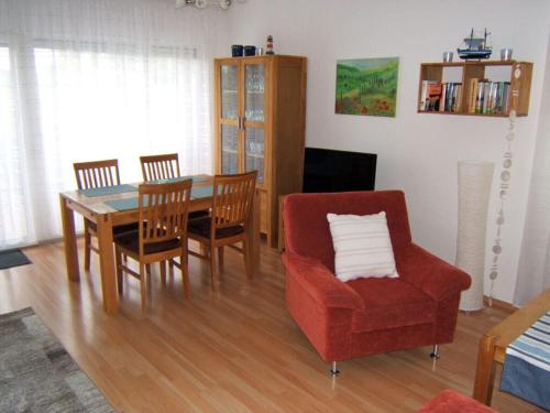 ein Wohnzimmer mit einem Esstisch und einem Stuhl in der Unterkunft Holiday apartment with a garden in Horumersiel