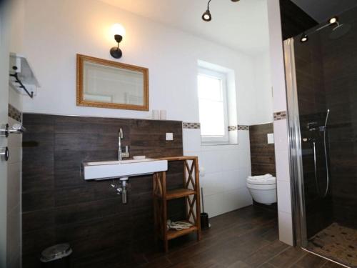 a bathroom with a sink and a shower and a toilet at To"n Lüchtfüer Comfortable holiday residence in Dwarsdorf
