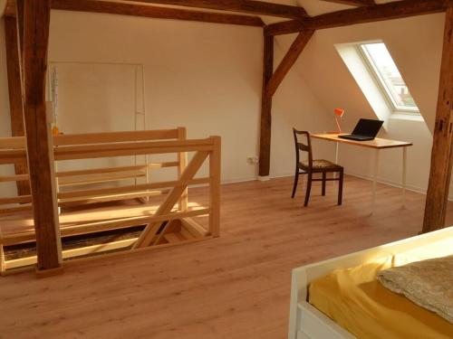 um quarto com um beliche e uma secretária com um computador portátil em Clay house with sauna em Tangermünde