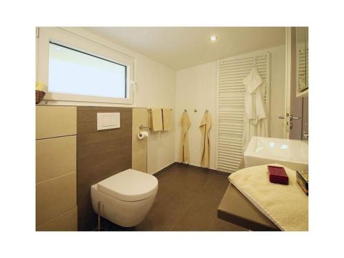 uma casa de banho com um WC, um lavatório e uma janela em Wamel Modern retreat em Möhnesee